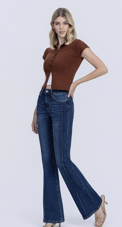 Woman wearing dark wash high rise pintuck flare jeans with comfort stretch